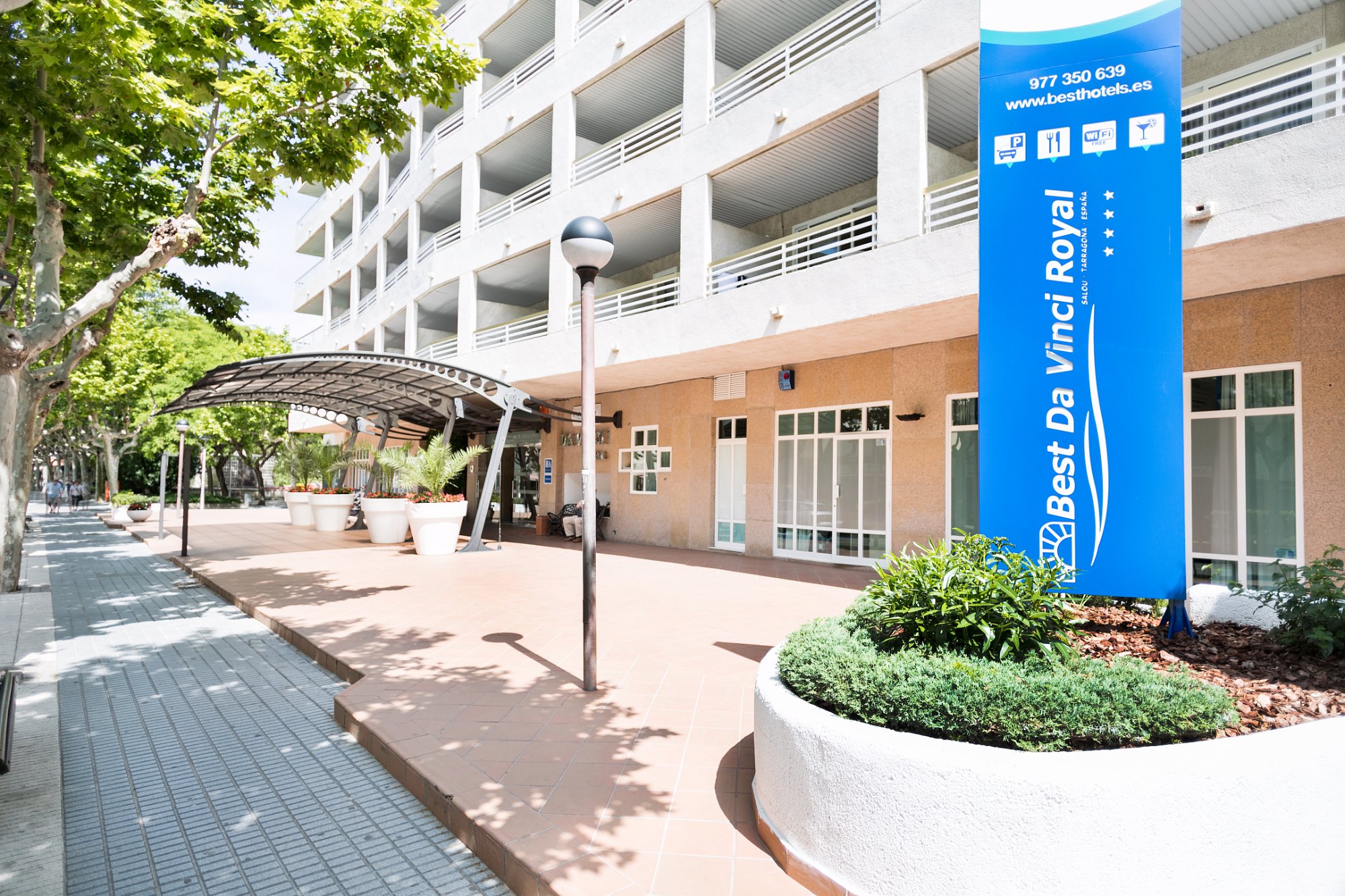 Best Da Vinci Royal viesnīcas galvenā ieeja un zilā izkārtne saulainā dienā