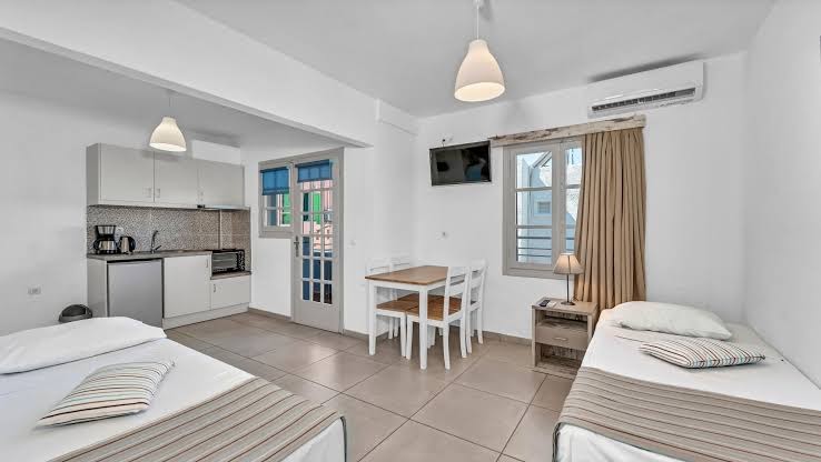 Evina Rooms & Suites studijas tipa numurs ar divām gultām, ēdamgaldu un nelielu virtuves zonu Stalidā, Krētā