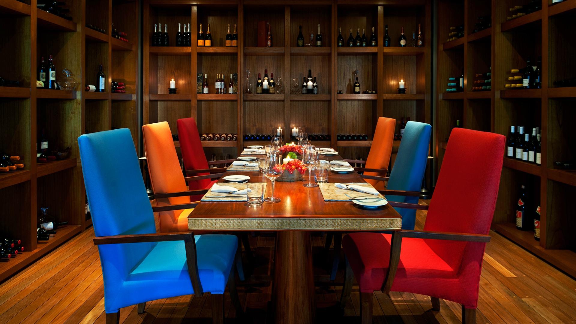 Kempinski Seychelles Resort privātā ēdamzāle ar plašu vīna kolekciju un košu interjeru