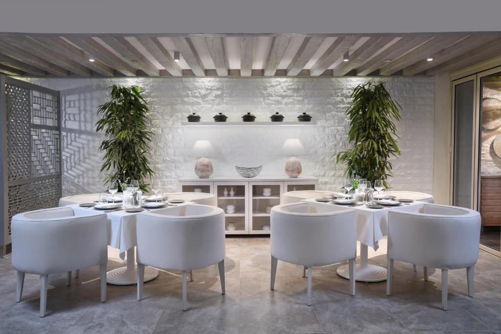 Elegants restorāns Steigenberger Resort Ras Soma ar baltām mēbelēm un zaļām augu dekorācijām.