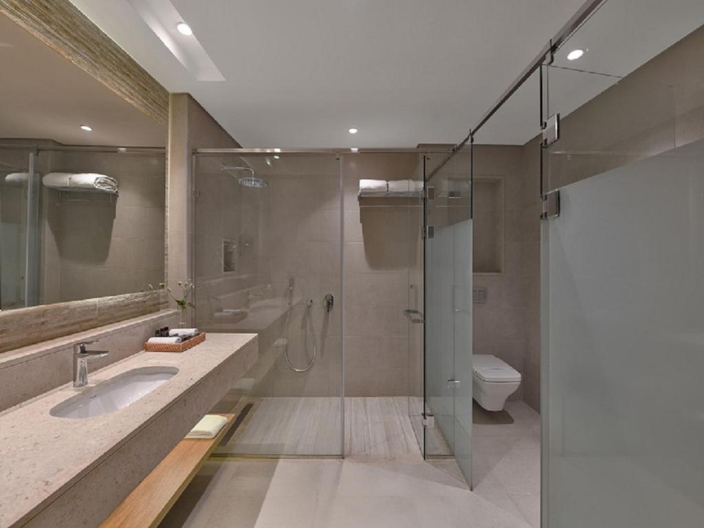 Mūsdienīga vannas istaba ar stikla dušu viesnīcā Steigenberger Resort Ras Soma.