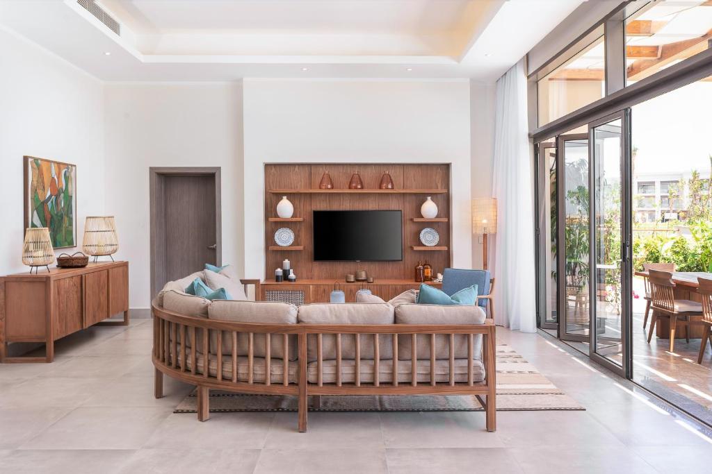 Mūsdienīgs viesistaba Steigenberger Resort Ras Soma ar lielu dīvānu un televizoru.