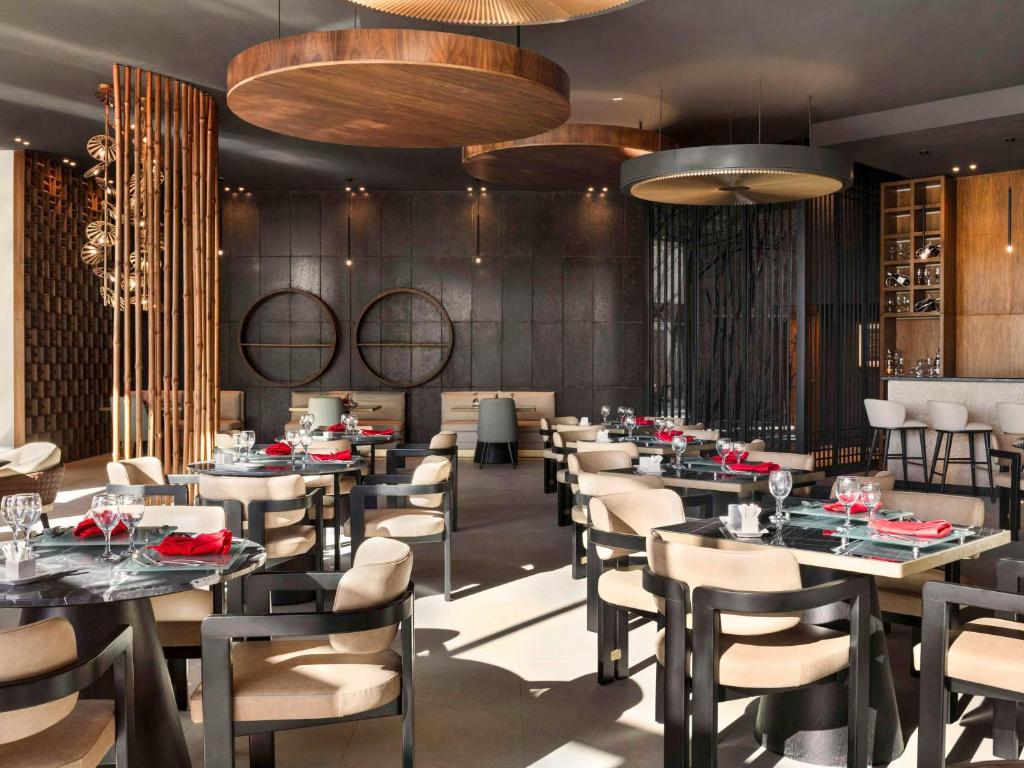 Mūsdienīgs restorāns Pickalbatros Golf Luxury Suites ar elegantiem galdiem un interjeru.