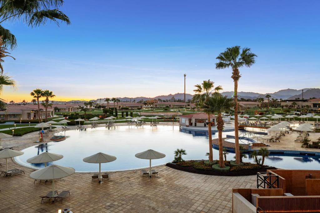 Skats uz baseinu un palmām pie Pickalbatros Golf Luxury Suites.