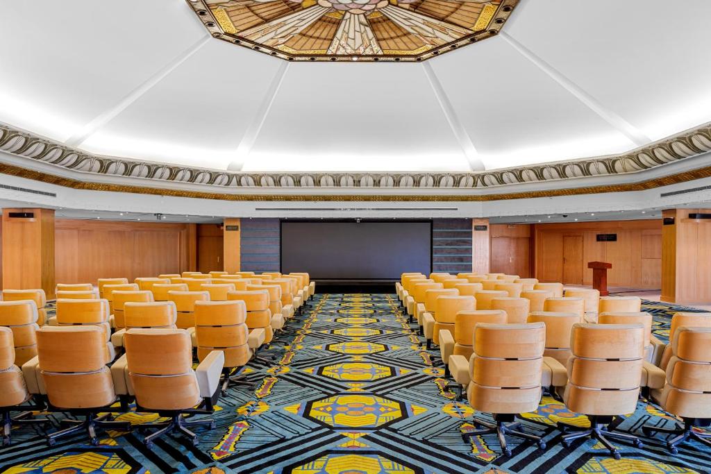 Konferenču telpa ar sēdvietām un ekrānu hotelī Pickalbatros Golf Luxury Suites.