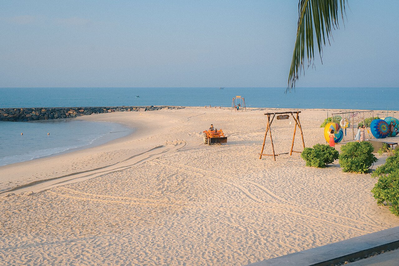 Pludmale pie The Cliff Resort & Residences ar smilšu un jūras ainavu.