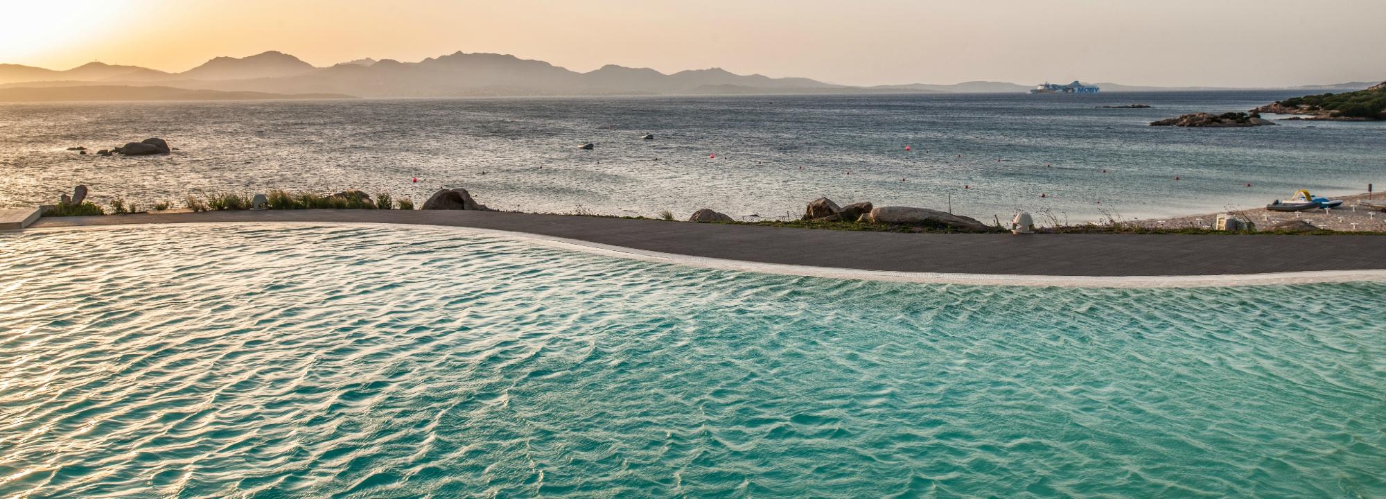 Cala Cuncheddi baseins ar skatu uz jūru saulrieta laikā.