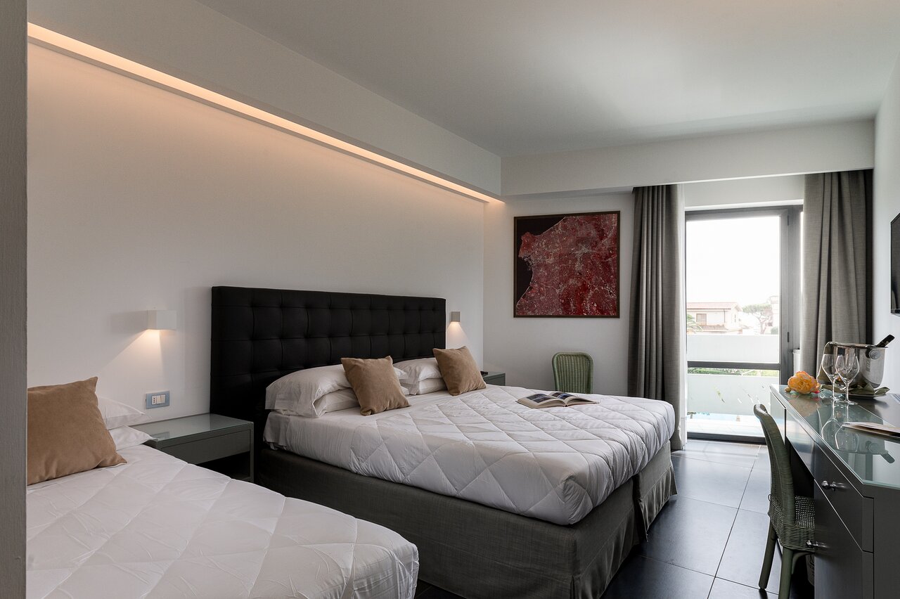 Modern numurs Rada Siri Hotel ar lielu gultu un balkonu.