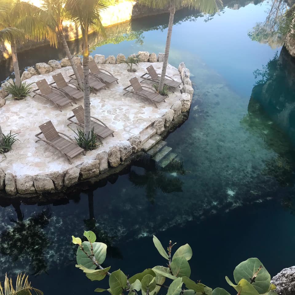 Xcaret Mexico viesnīcas atpūtas zona pie ūdens ar sauļošanās krēsliem.