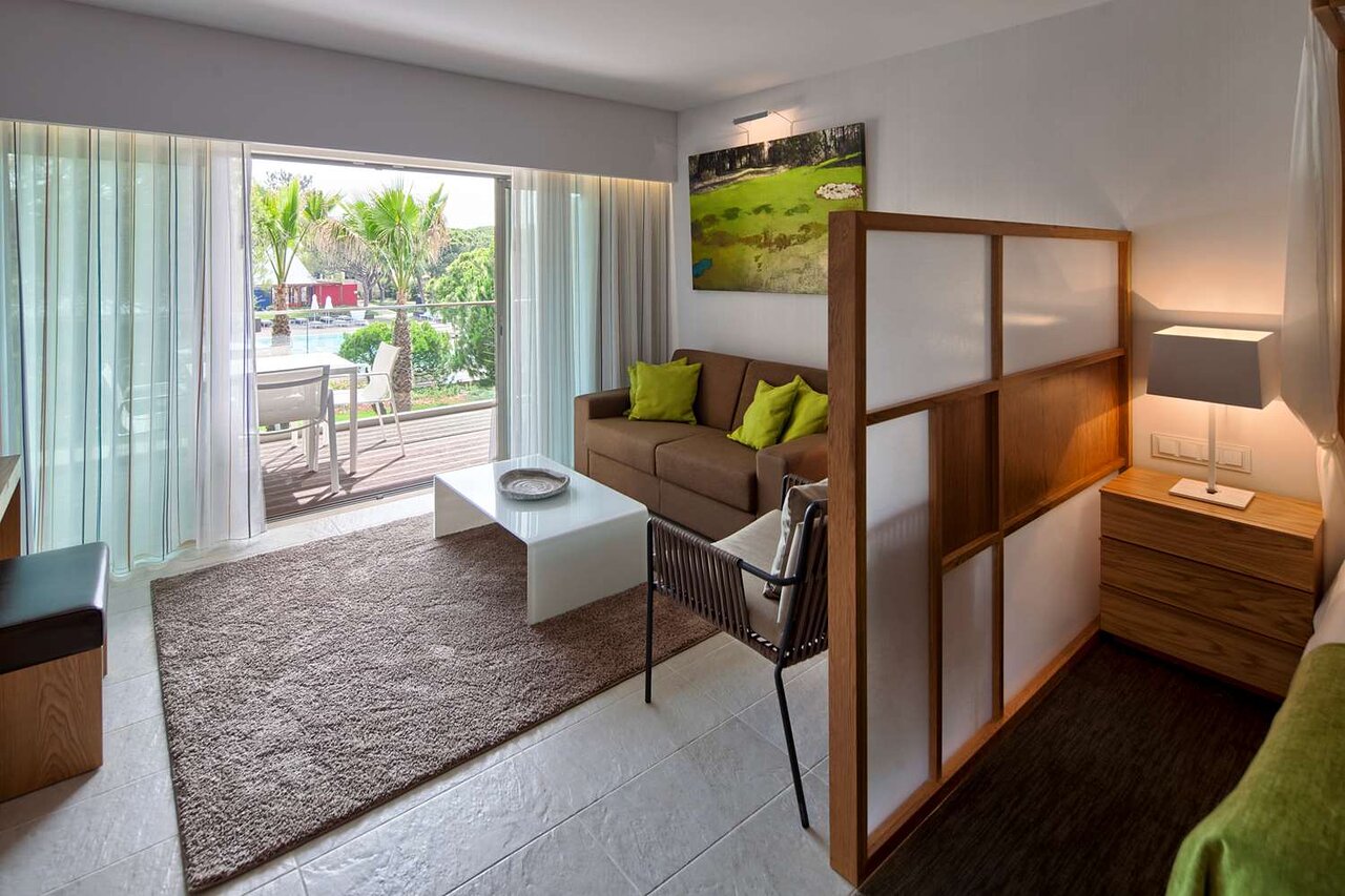 Moderns EPIC SANA Algarve Hotel numurs ar atpūtas zonu un izeju uz terasi.