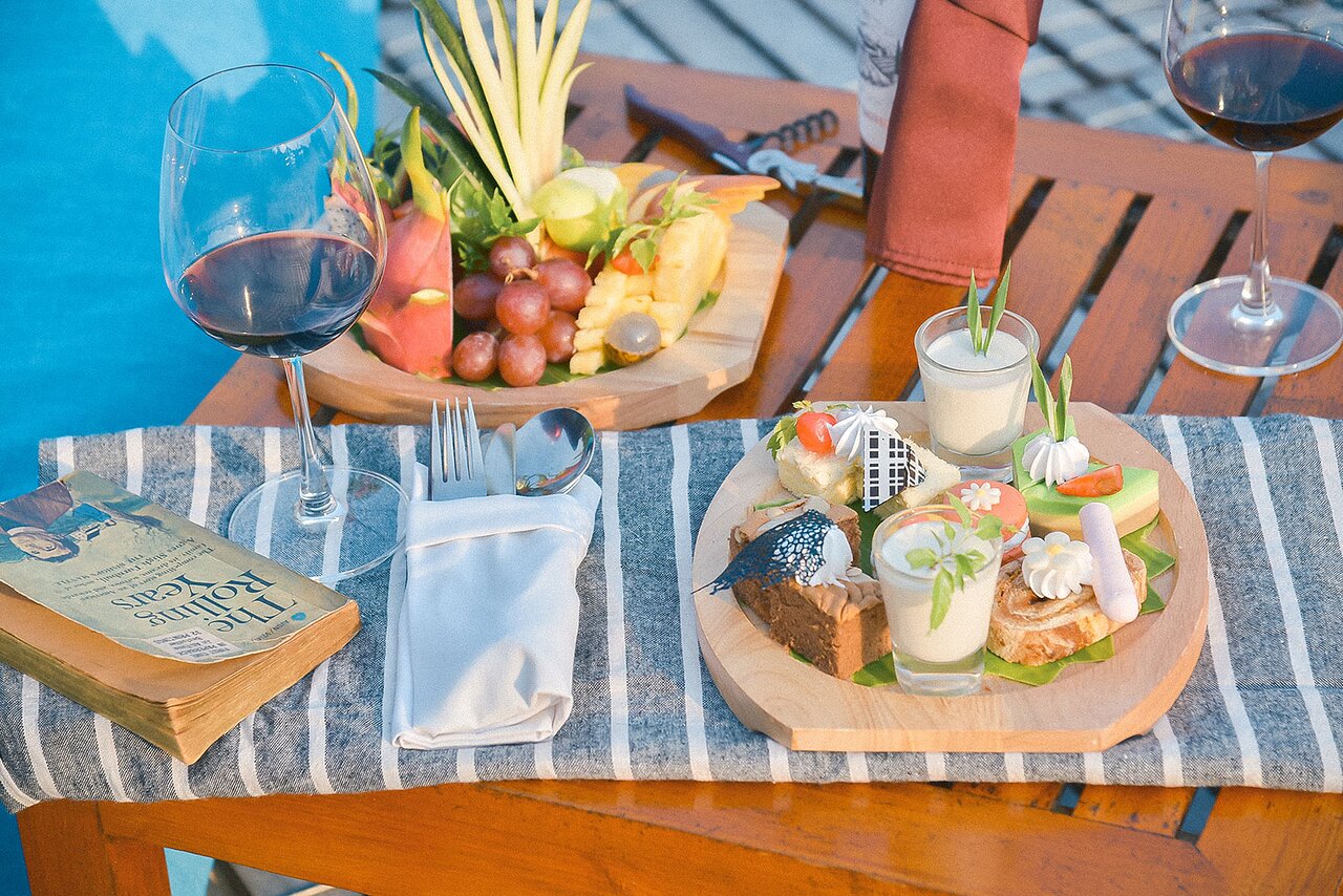 Gurme uzkodas un vīns pie baseina The Cliff Resort & Residences.