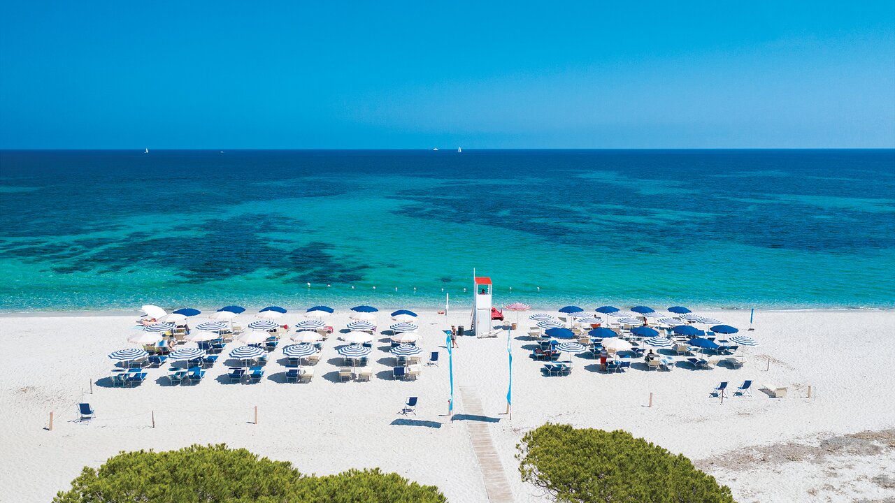 Futura Cala Fiorita pludmale ar saulessargiem un tirkīza jūru.