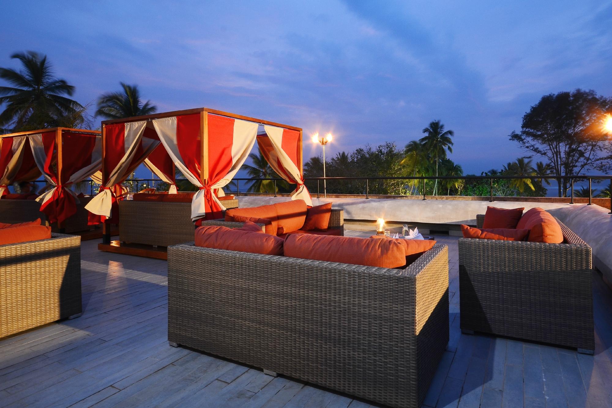 Cinnamon Bey terase ar skatu uz tropu dārzu krēslā.