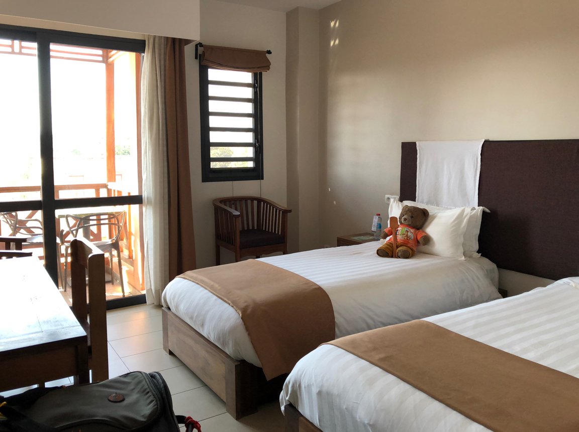 Hotel Plumeria numurs ar divām gultām un balkonu.