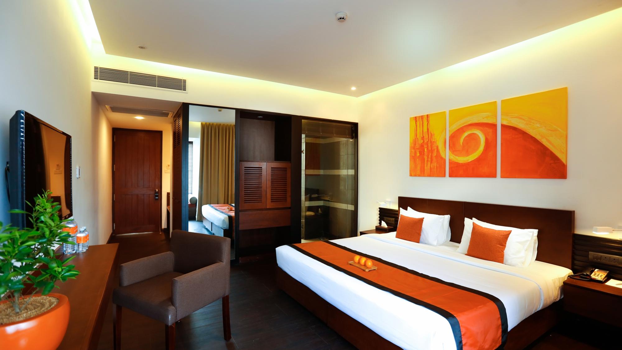 Citrus Waskaduwa moderna viesnīcas numurs ar spilgtiem akcentiem.