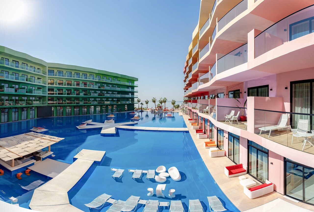 Voco Monaco Dubai viesnīca ar baseinu un krāsainu fasādi.