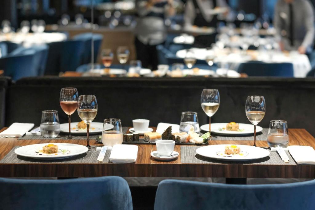 Eleganti sakārtota galda aina restorānā Paloma Perissia ar izsmalcinātām uzkodām un dzērieniem.