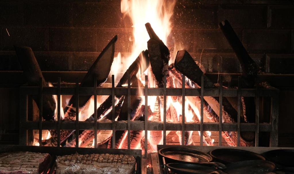 Kamīns ar uguni un grilētiem gaļas gabaliem viesnīcā Paloma Perissia.