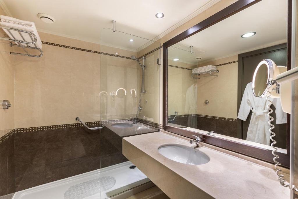 Eleganta vannas istaba viesnīcā Paloma Perissia ar mūsdienīgu dušu un spoguli.