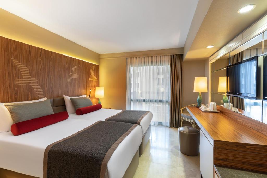 Mūsdienīgs numurs viesnīcā Paloma Perissia ar divām gultām un plašu logu