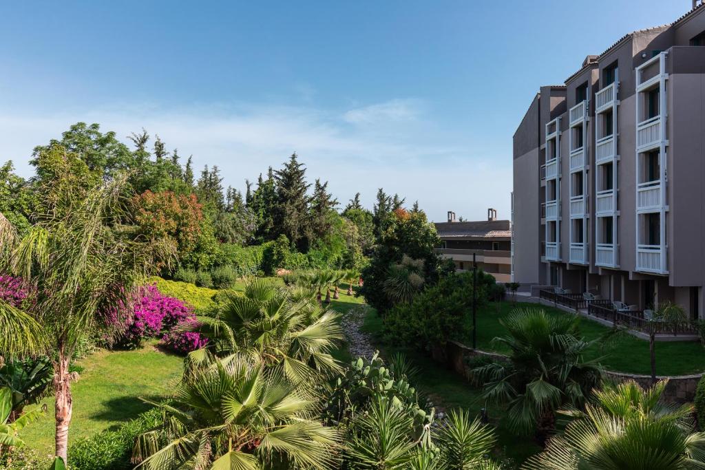 Paloma Perissia viesnīca ar zaļiem dārziem un ziediem piekrastē