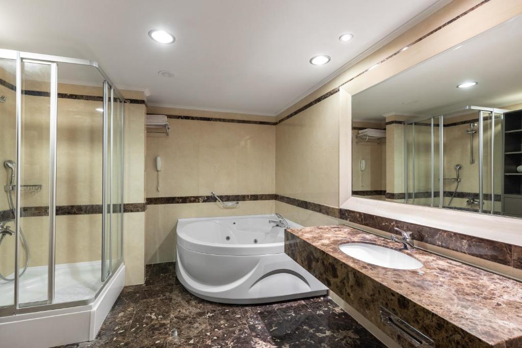 Mūsdienīga vannas istaba viesnīcā Paloma Perissia ar džakuzi un dušu.