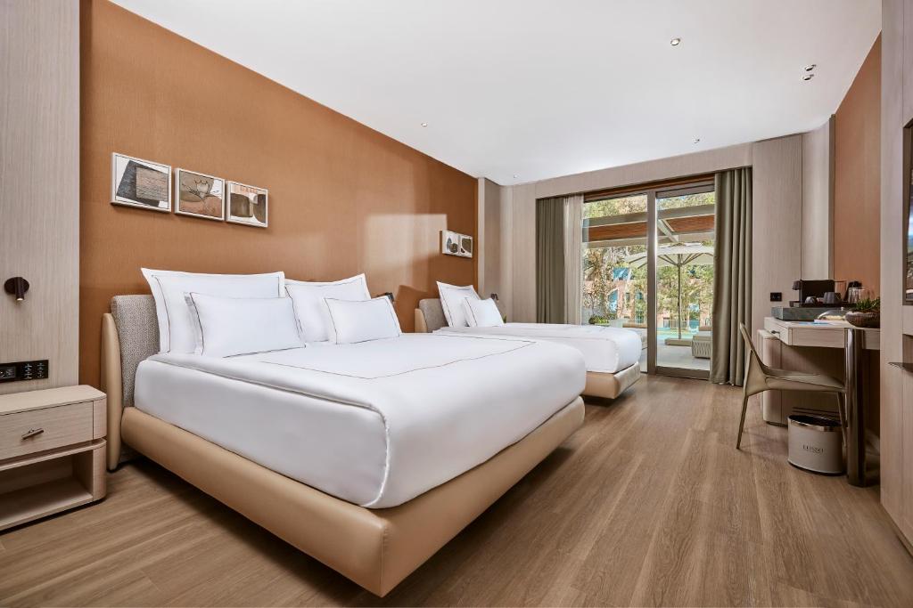 Lusso Sorgun numurs ar divām gultām un skatu uz dārzu.