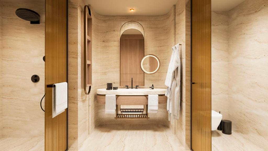 Mūsdienīgs vannas istabas interjers ar dabīgu akmens apdari, koka elementiem un elegantu sanitāro aprīkojumu. Vannas istaba ir gaiša un plaša, veidojot relaksējošu atmosfēru.