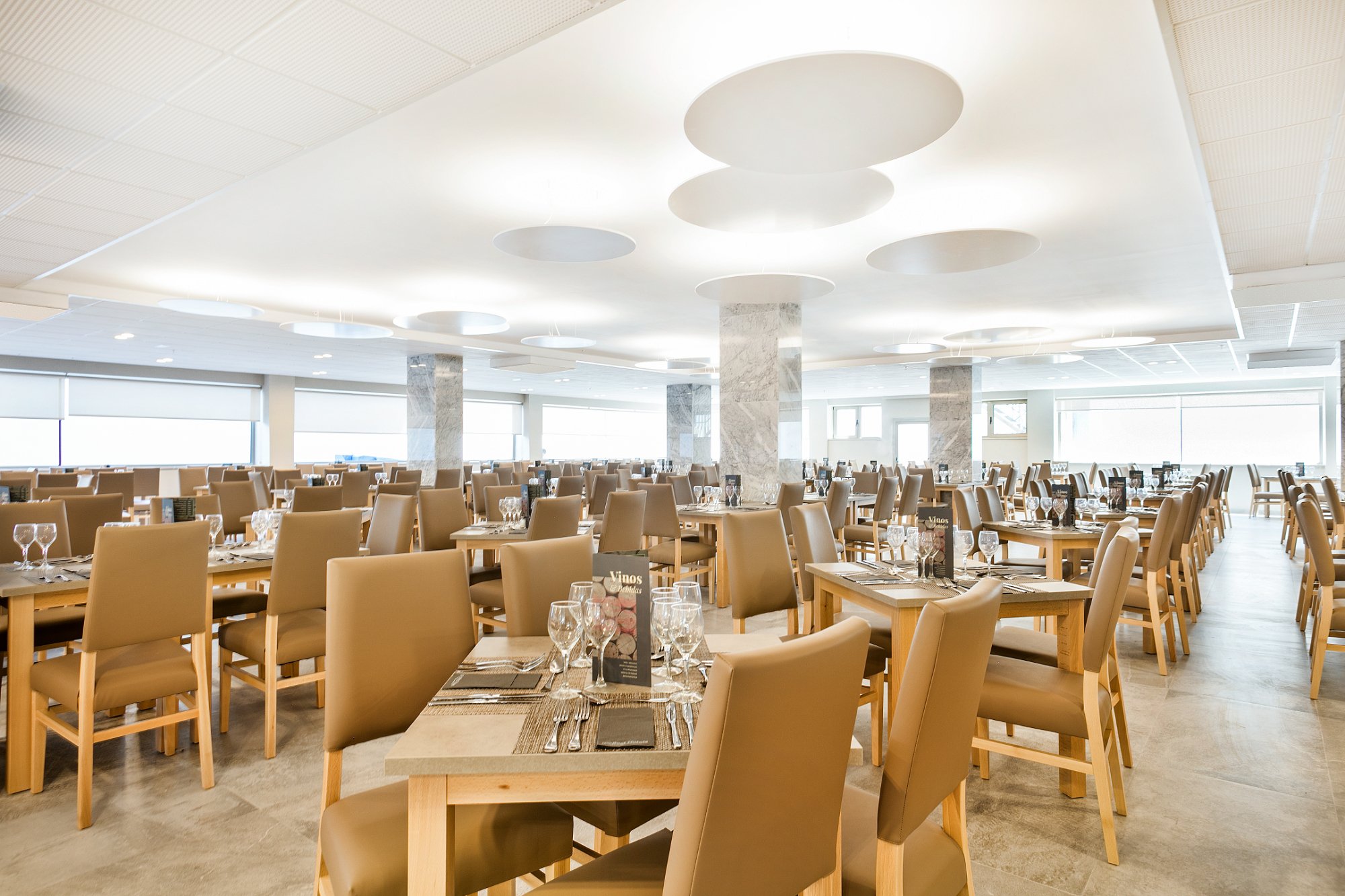 Plaša un gaiša Best San Diego restorāna zāle ar elegantiem galdu klājumiem un ērtiem krēsliem.