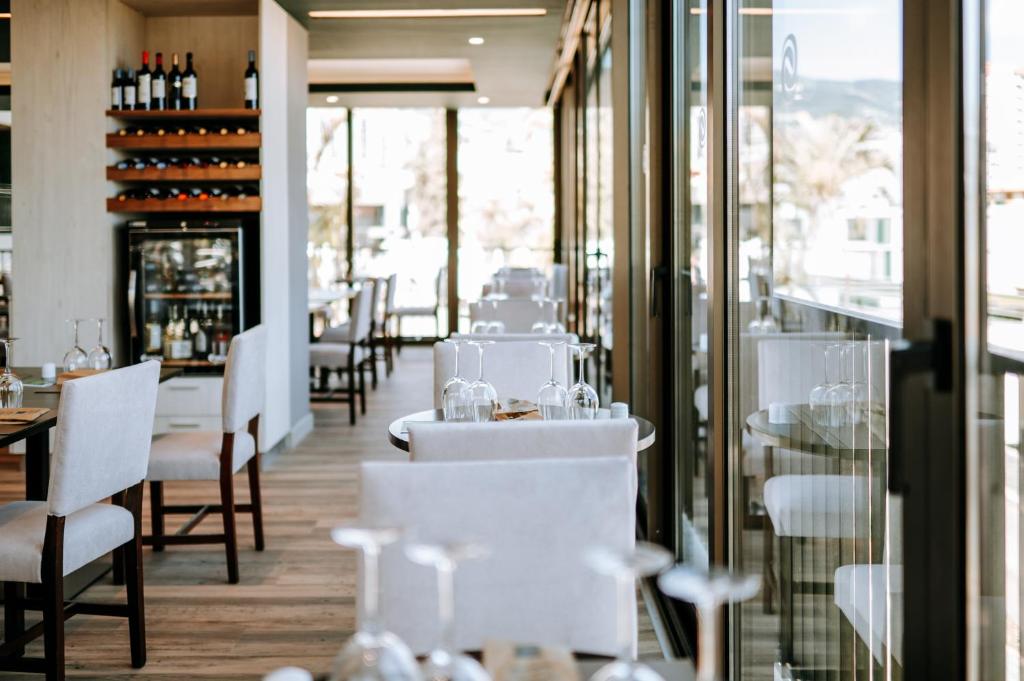 Gaišs un moderns restorāna interjers ar koka grīdu, elegantiem galdiem un krēsliem, kā arī vīna plauktu, kas piepildīts ar pudelēm. Lielas logu vitrīnas sniedz skatu uz āru.