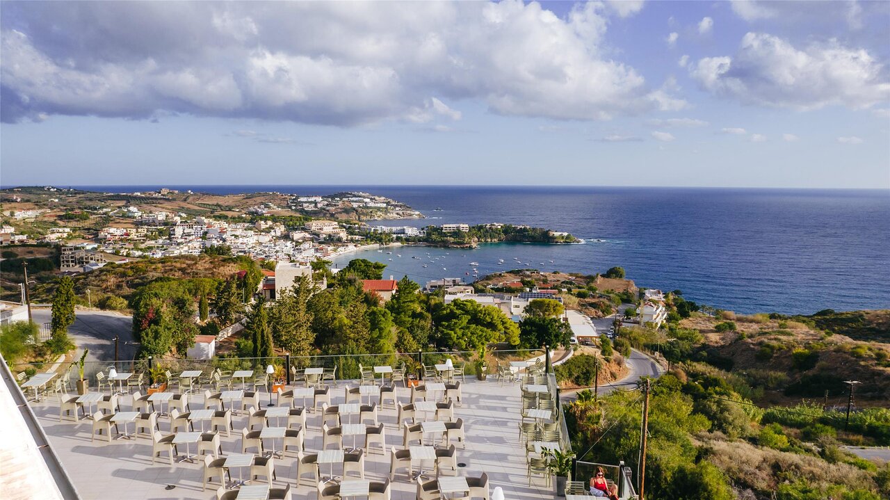 Panorama Village Hotel āra terase ar galdiņiem un plašu panorāmas skatu uz piekrastes līci