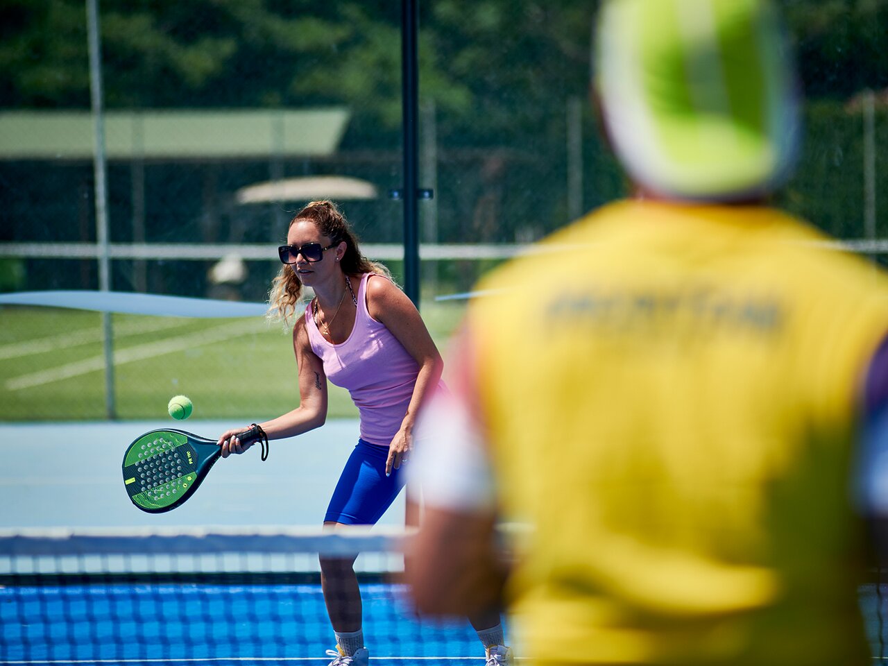 Sieviete spēlē tenisu Serene Resort tenisa kortā.