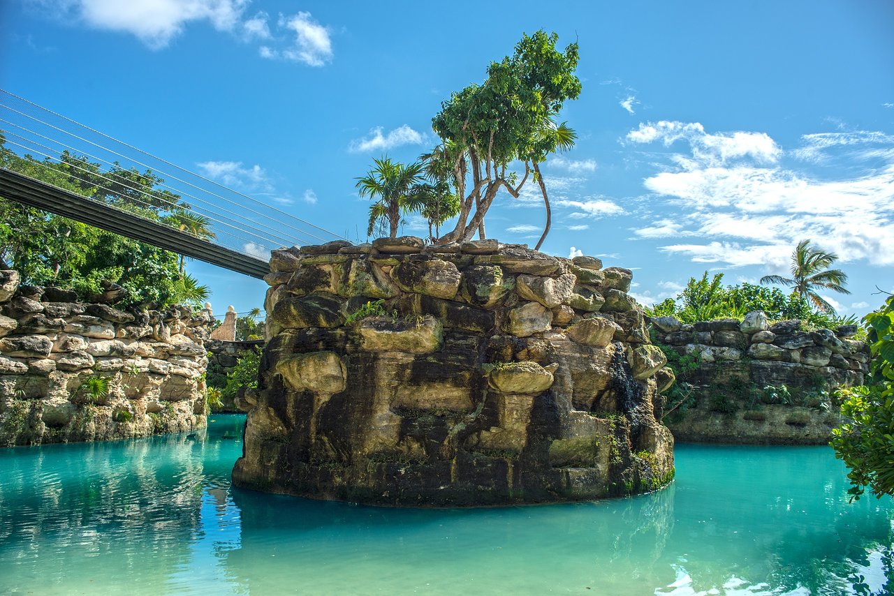 Dabas skats pie Xcaret Mexico viesnīcas ar klinšu veidojumiem un tiltu.