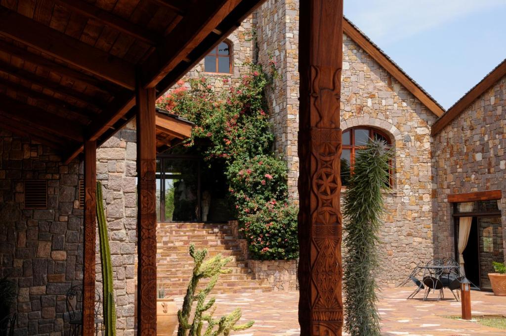 Jardin du Roy viesnīcas akmens fasāde ar ziediem un kaktusiem