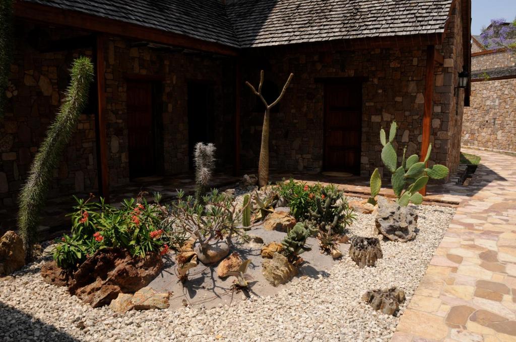 Dārza ainava pie viesnīcas Jardin du Roy ar kaktusiem un akmeņiem.