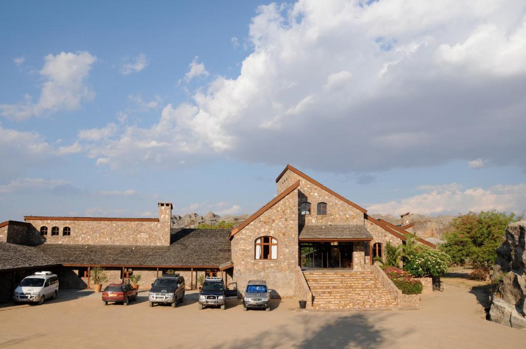 Jardin du Roy viesnīca ar akmens fasādi un automašīnām pie ieejas