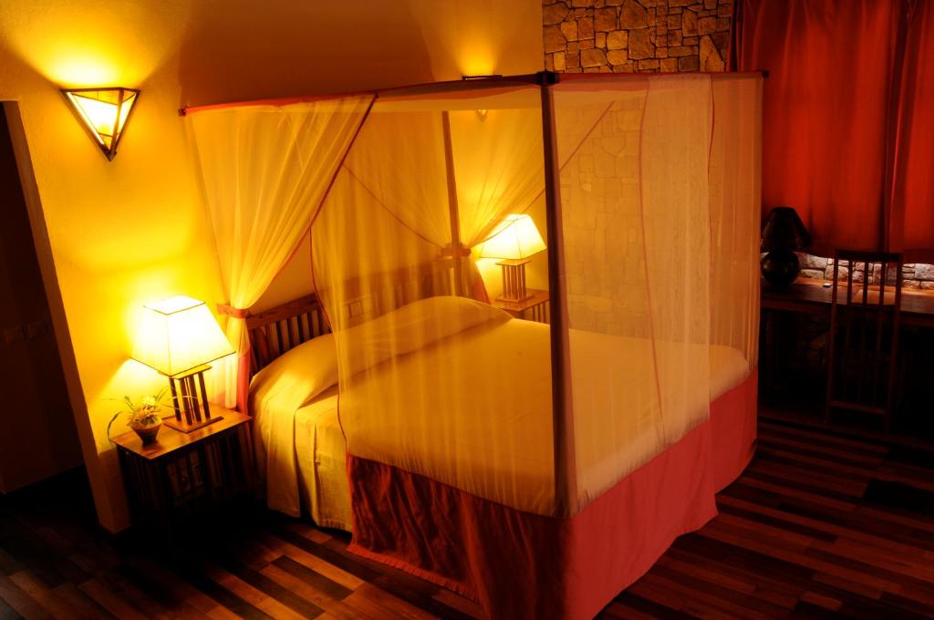 Jardin du Roy romantisks numurs ar gultu, apgaismojumu un mežģīņu aizkariem.