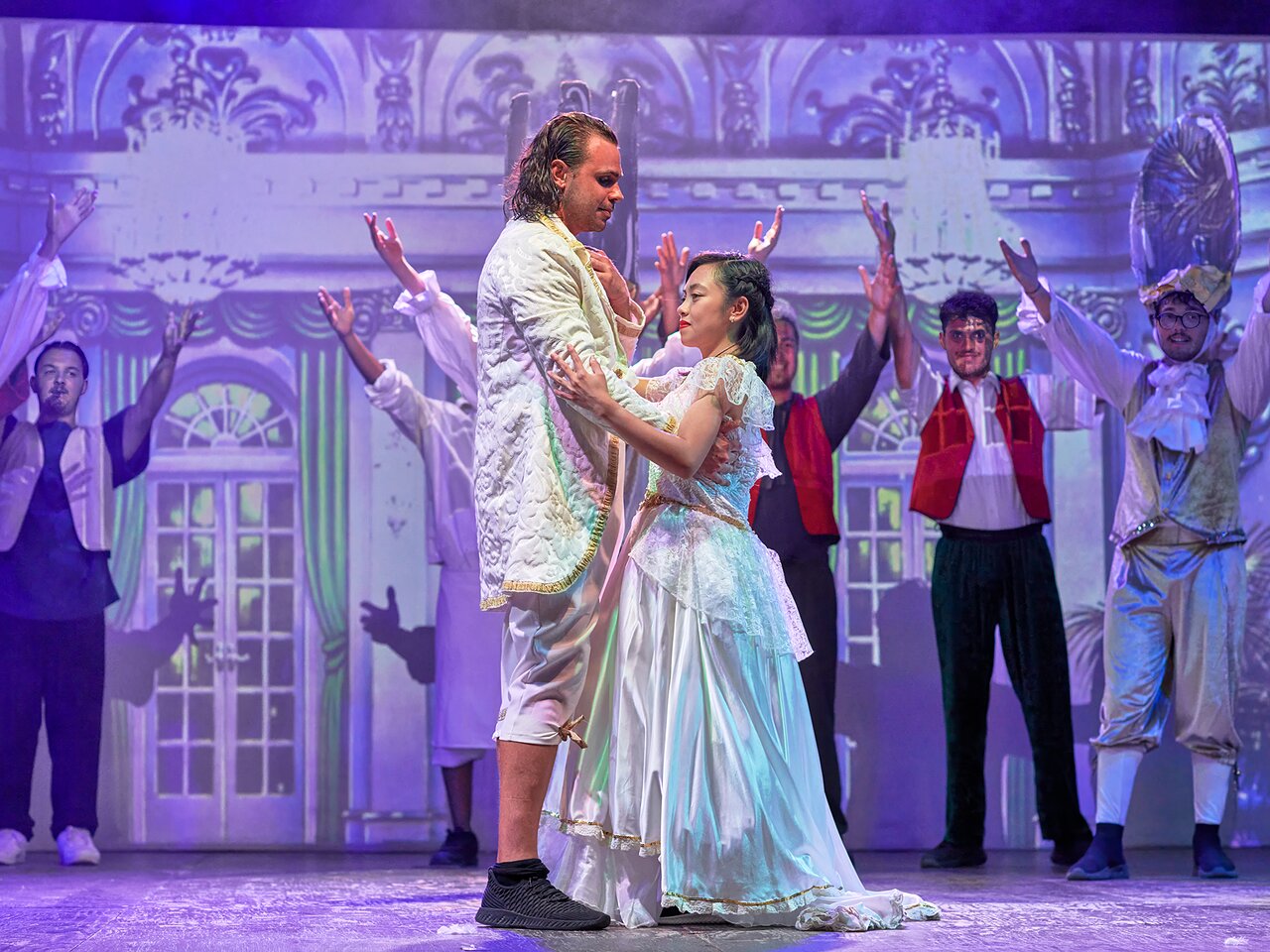 Teātra izrāde ar dejotājiem elegantos kostīmos.