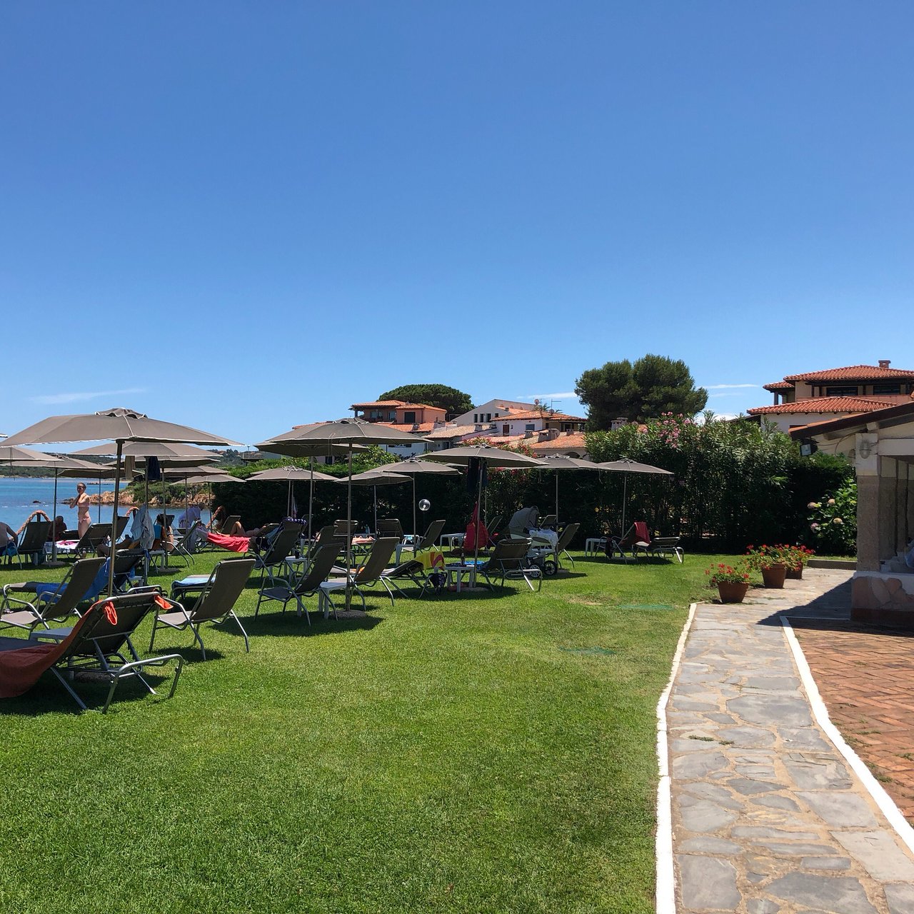 San Paolo viesnīcas dārzs ar pludmales krēsliem piekrastē.