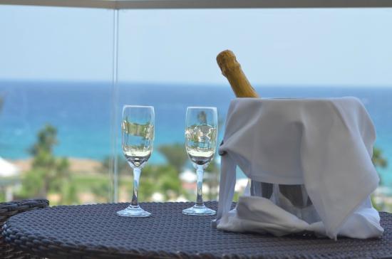 Adams Beach skats uz jūru ar šampanieti un glāzēm.