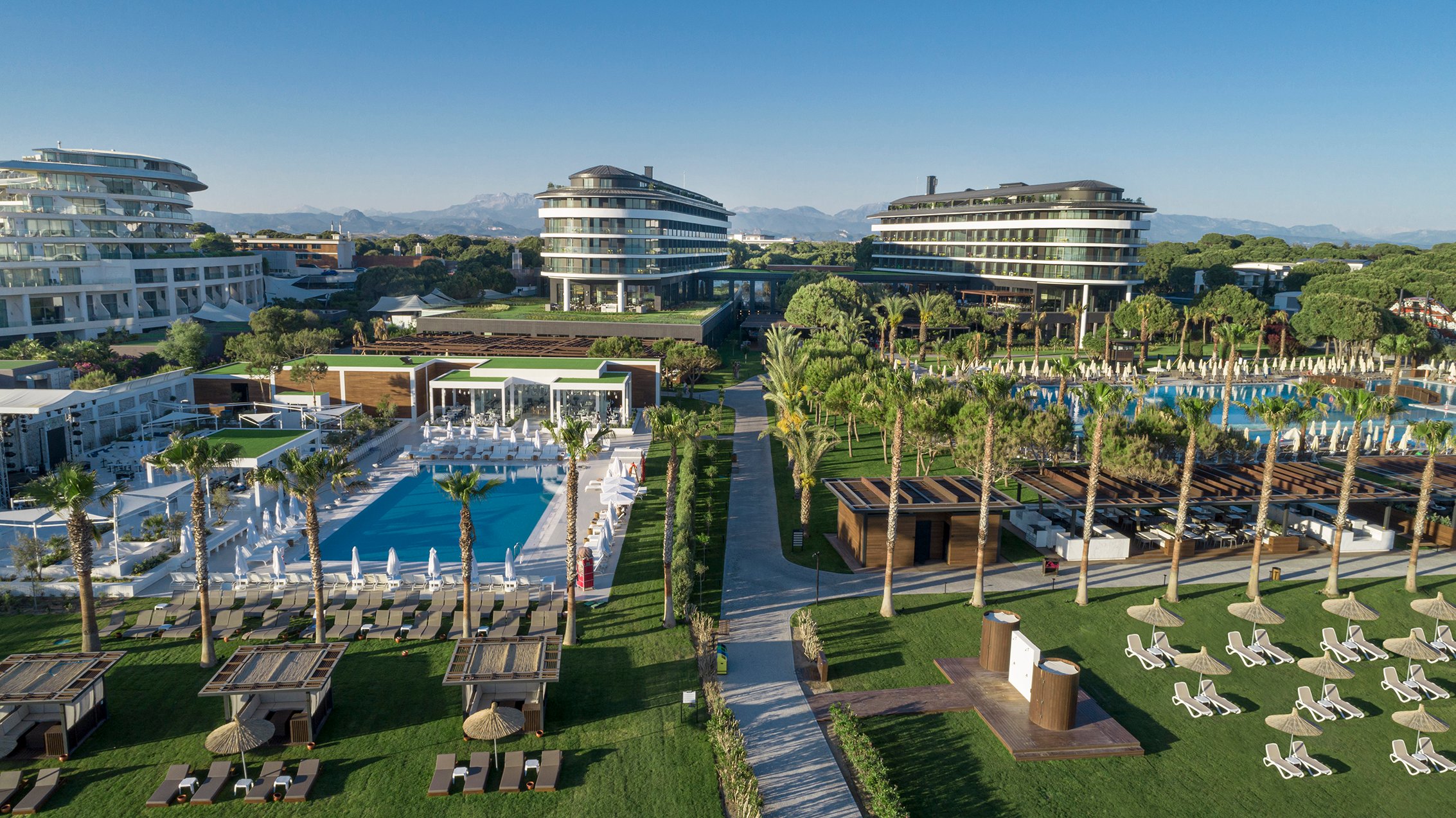 Skats uz Voyage Belek Golf & Spa viesnīcu ar baseinu un atpūtas zonām