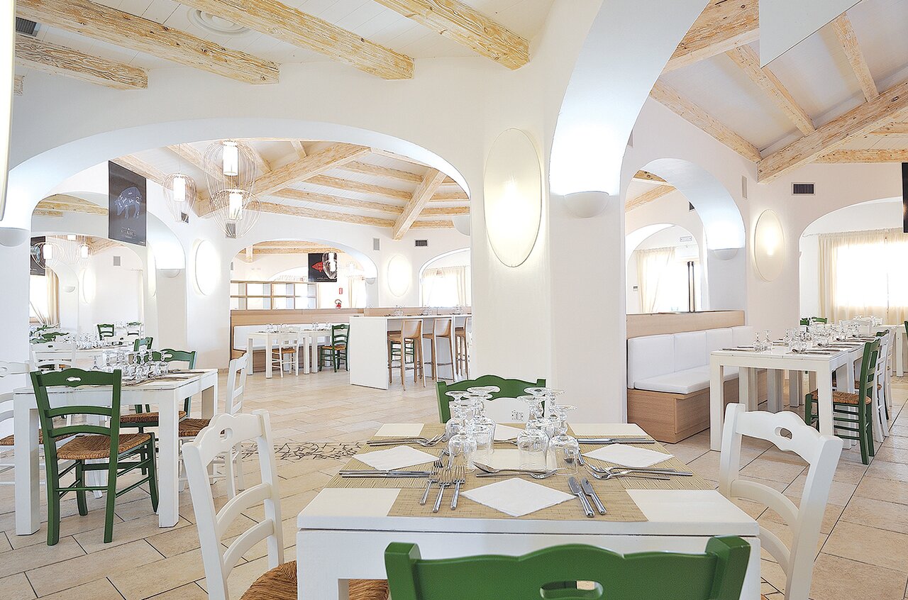 Janna 'e Sole Resort gaišais restorāns ar tradicionālām arkām un koka sijām