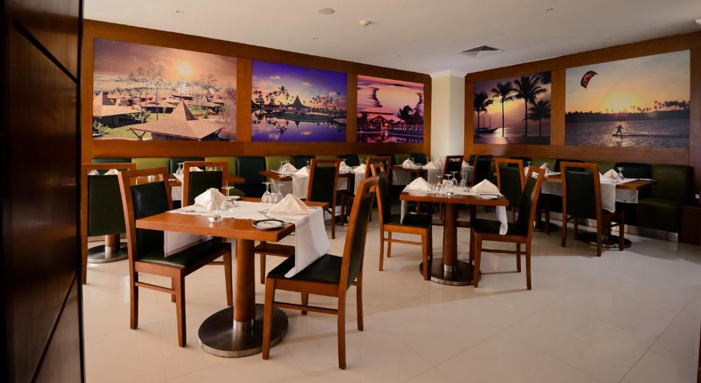 Vila Gale Atlantico elegantā restorāna interjers ar galdiem un mākslas darbiem.