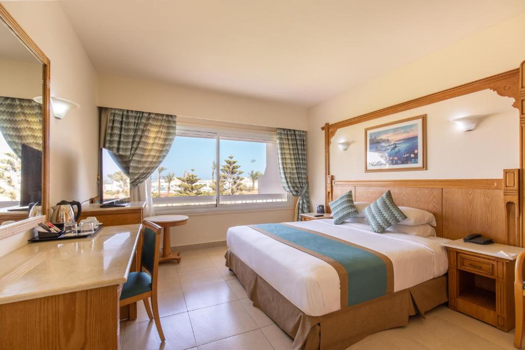 Numurs viesnīcā Long Beach Resort Hurgada ar gultu un skatu uz dārzu.