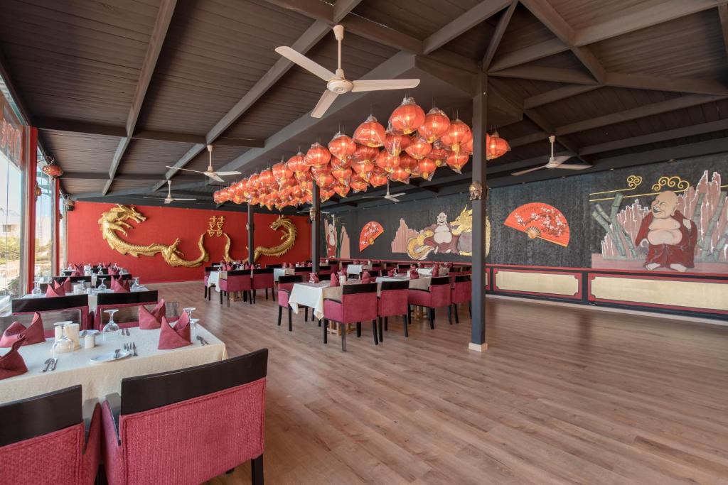 Ķīniešu restorāns Long Beach Resort Hurgada ar sarkaniem dekoriem un zeltainiem akcentiem.