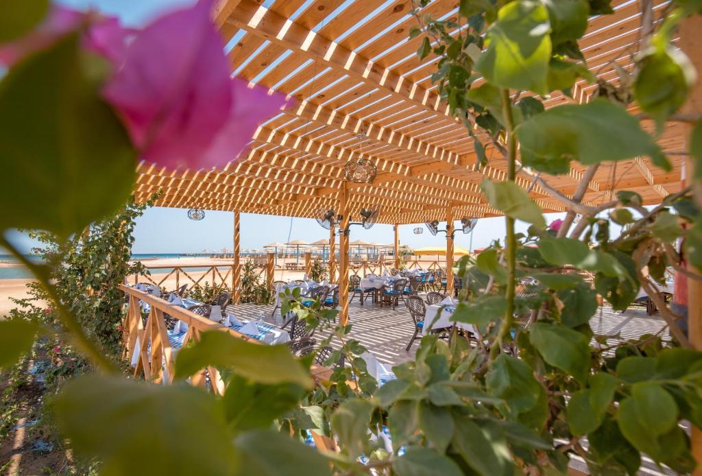 Kafejnīca piekrastē ar ziediem un ēdamgaldiem Long Beach Resort Hurgada.