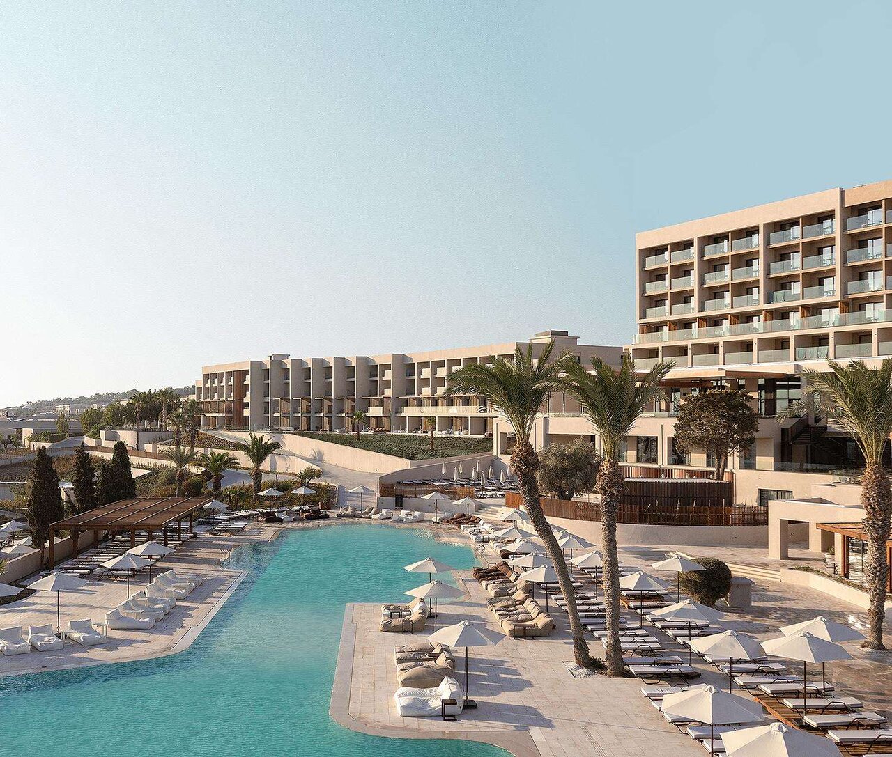 Mūsdienīgs kūrorts ar baseinu un palmām, kas atrodas saulainā vietā. Ideāla vieta relaksācijai un atpūtai. panoramic view with beach and pools