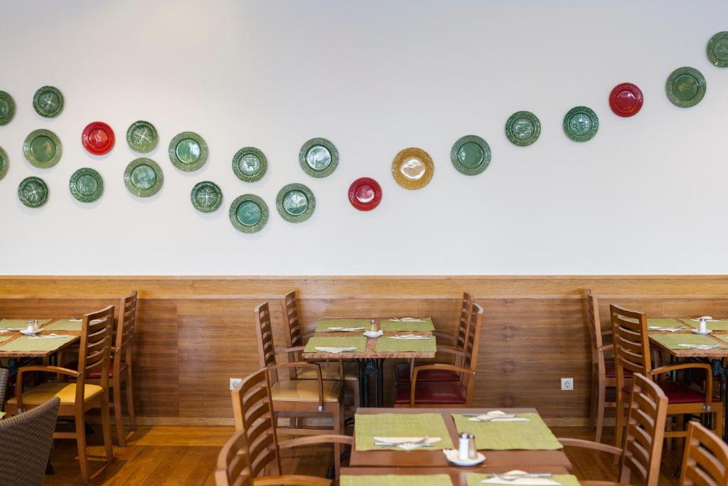 Restorāna interjers ar krāsainām plāksnēm pie sienas, Alfagar Alto da Colina