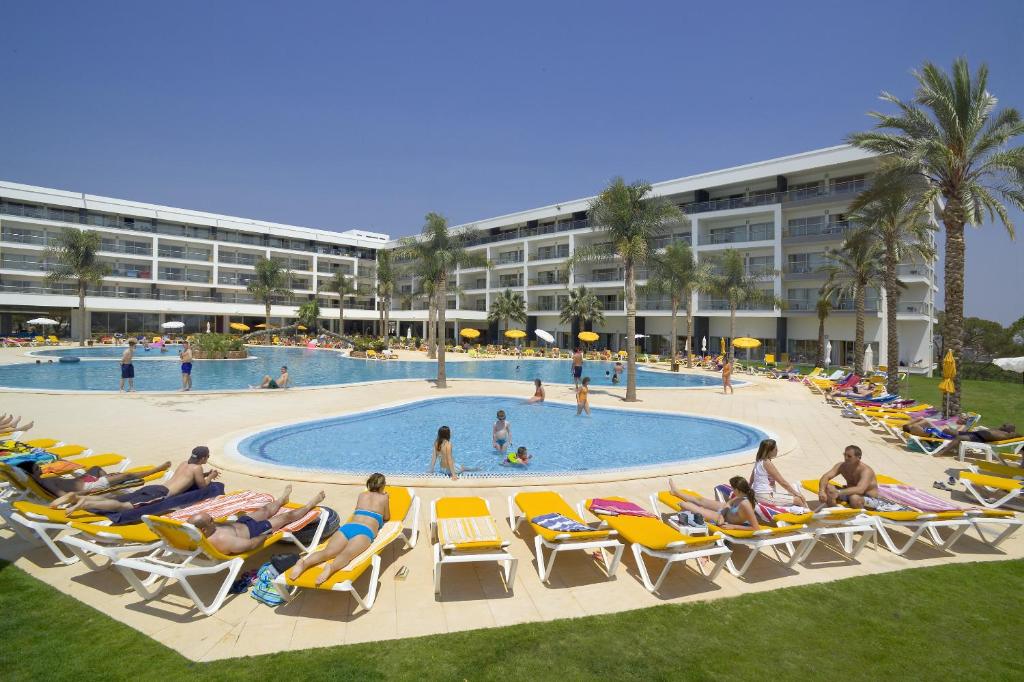 Viesnīca Alfagar Alto da Colina ar baseinu un sauļošanās krēsliem piekrastē.