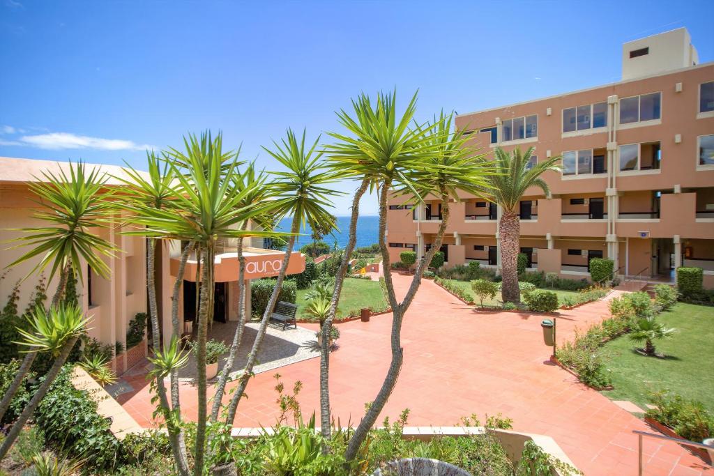 Auramar Beach Resort ieeja ar zaļajiem augiem un skatu uz jūru